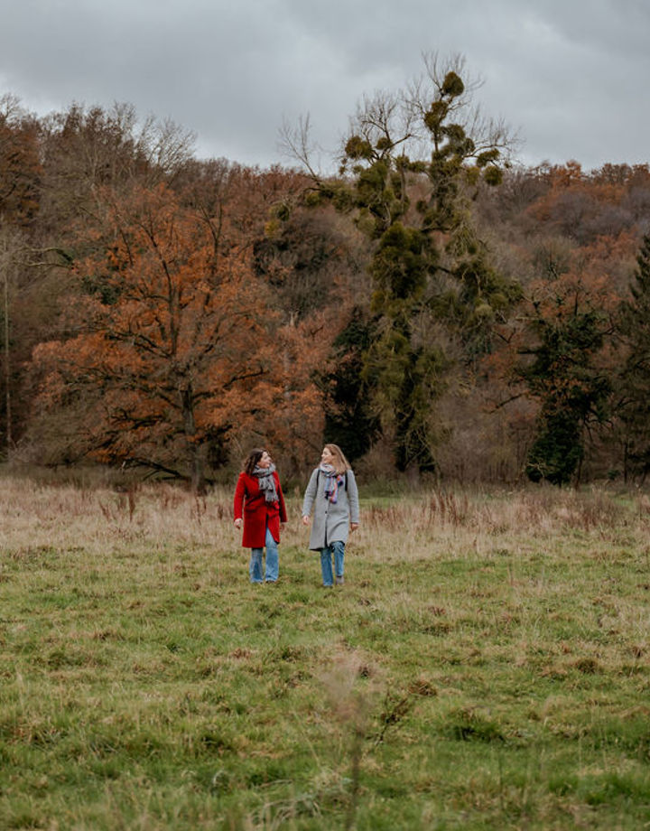 Twee wandelaars in natuurgebied Ingendael met het bos op de achtergrond. 